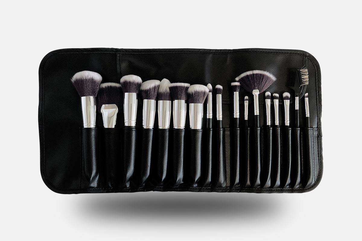 Set of makeup brushes in a black case on a white background