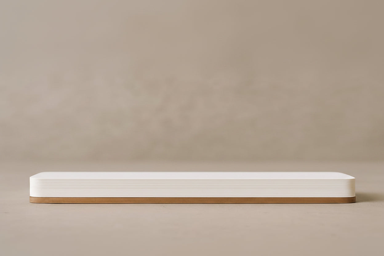 Long, narrow white bench with a wooden base on a beige background