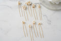 Gold hairpins with pearls on a marble surface