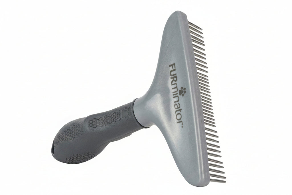 Gray grooming brush with comb attachment on a white background, featuring the FURMINATOR brand.