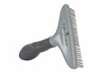 Gray grooming brush with comb attachment on a white background, featuring the FURMINATOR brand.