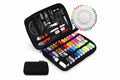 Sewing kit with threads, pins, and tools in a black case on a white background