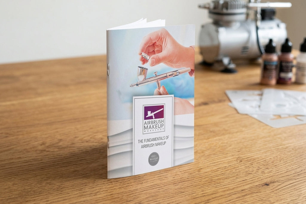 Book titled 'Airbrush Makeup' on a wooden surface with a blurred background