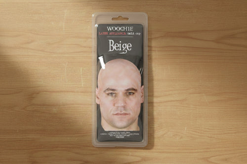 Packaged bald cap labeled 'Beige' on a wooden surface