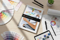 Color consulting book on a desk with color swatches and a tablet displaying color options.