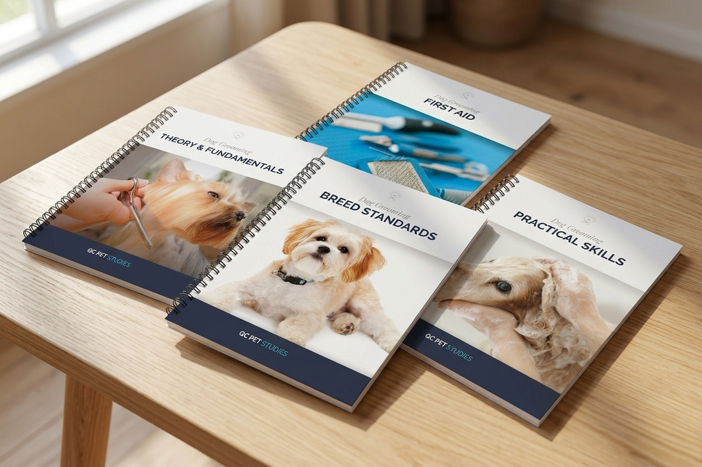 Four dog grooing training books on a wooden table