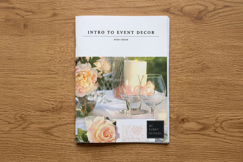 Book titled 'Intro to Event Decor' on a wooden surface