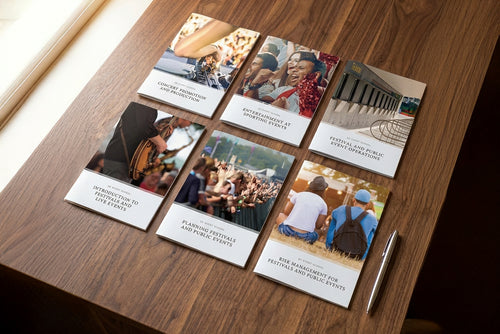 Collection of event promotion booklets on a wooden surface
