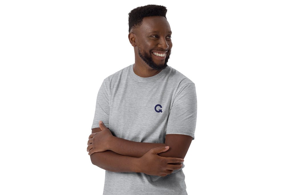 Man wearing a gray t-shirt with a QC logo on a white background