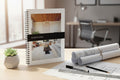 Home staging book on a desk with architectural plans and a plant