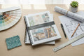 Design book with color swatch, floor plans, and stationery on a desk