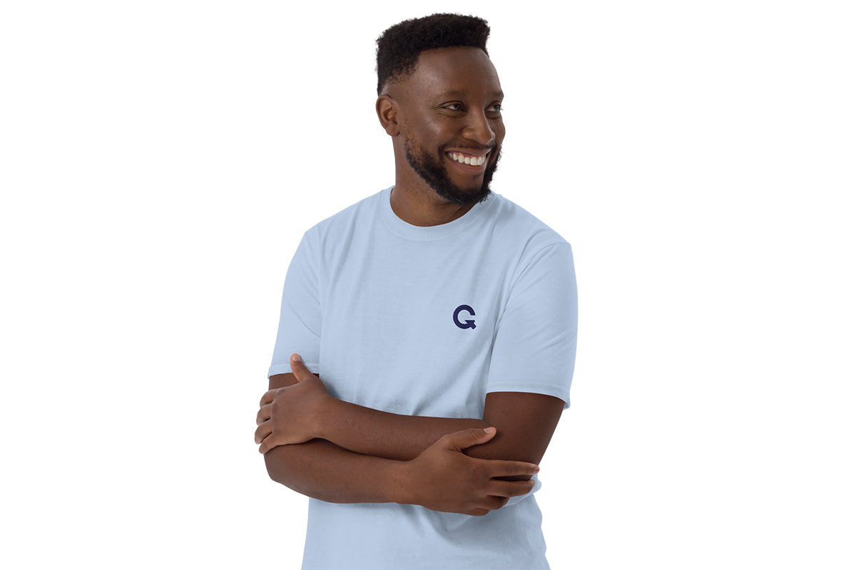 Man wearing a light blue t-shirt with a QC logo on a white background