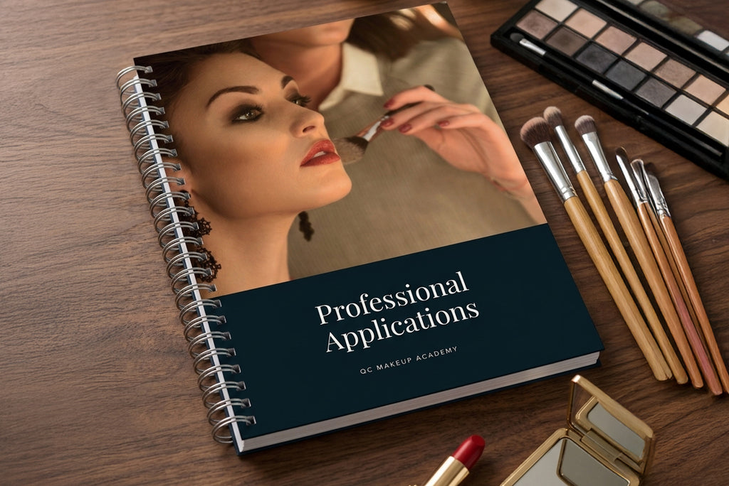 Makeup notebook titled 'Professional Applications' by QC Makeup Academy on a wooden surface with makeup tools.
