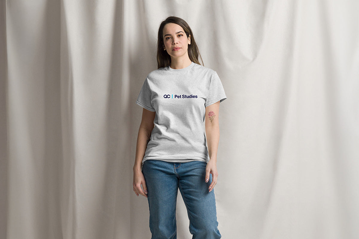 Person wearing a gray t-shirt with QC Pet Studies Logo on a plain background
