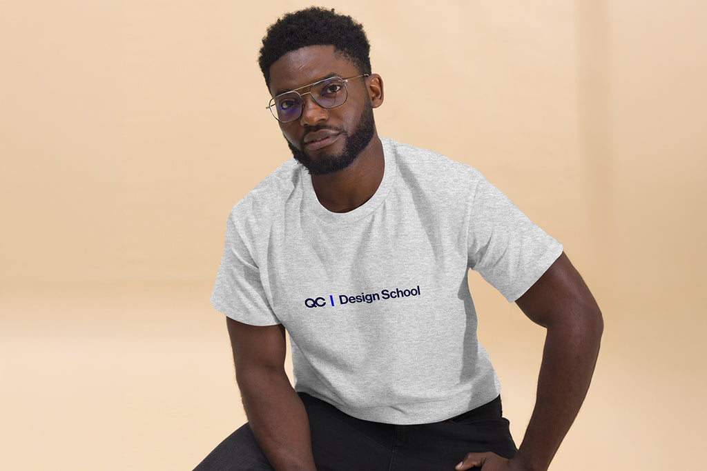 Man wearing a gray t-shirt with 'OC Design School' text on a beige background