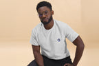 Man wearing a gray t-shirt with 'OC Design School' text on a beige background