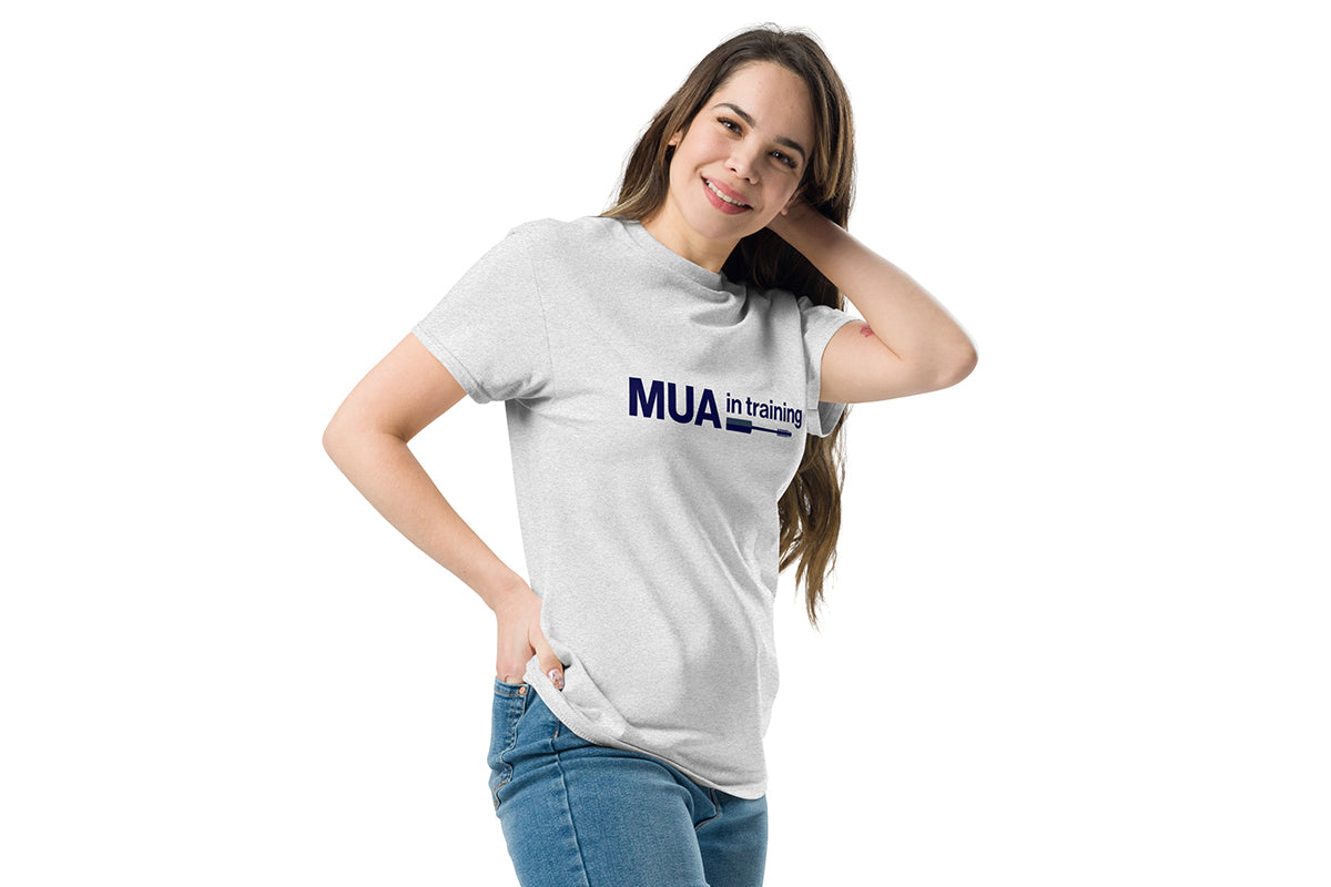 Woman wearing a light gray t-shirt with 'MUA in training' text on a white background