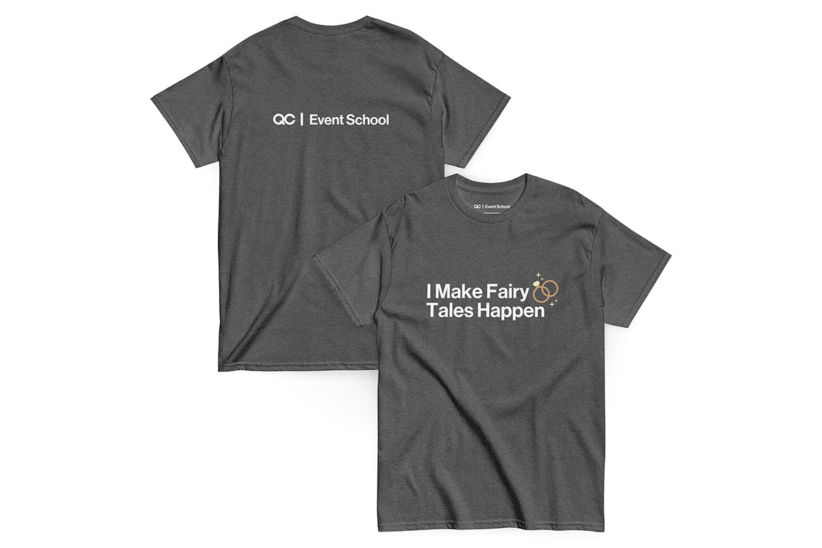 Grey t-shirt with text 'I Make Fairy Tales Happen' on a white background. Back of t-shirt reads "QC Event School".