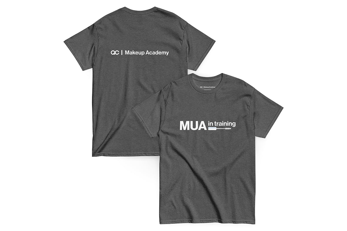 Gray t-shirt with text 'MUA in Training' on a white background. Back of t-shirt reads "QC Makeup Academy".