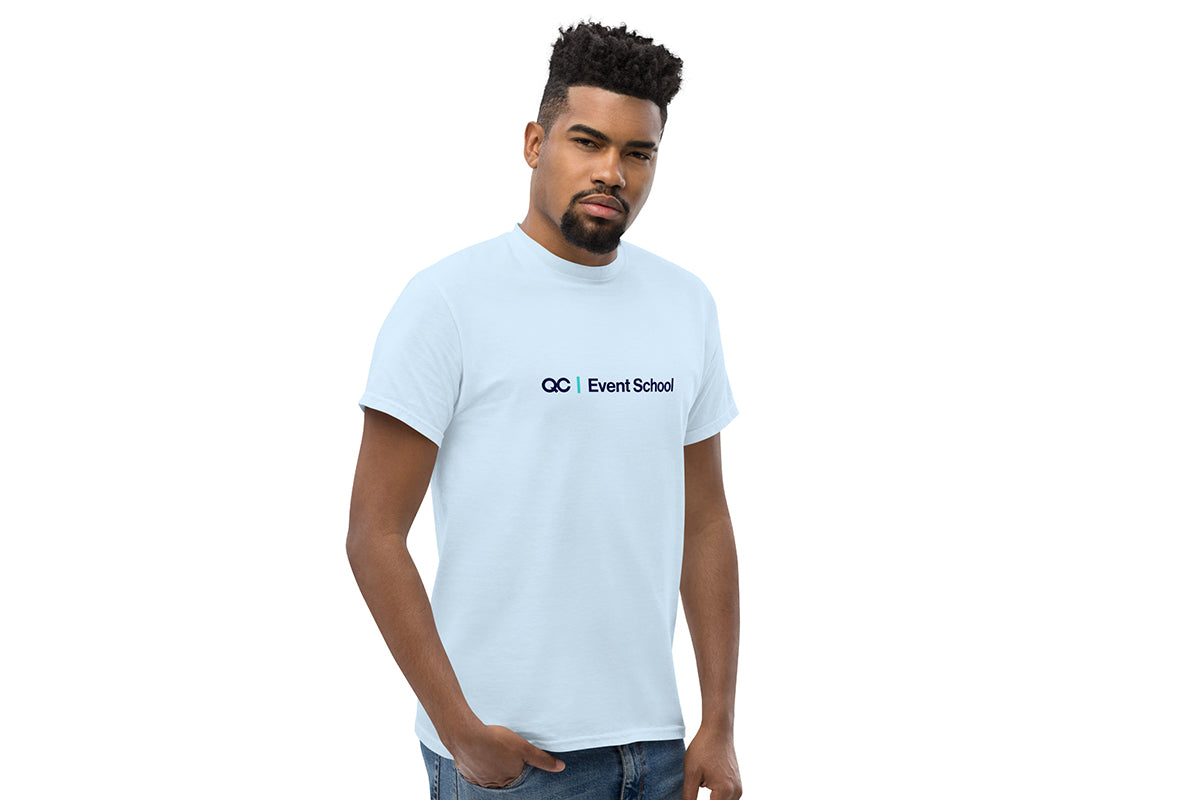 Man wearing a light blue t-shirt with a QC Event School logo and text on a white background