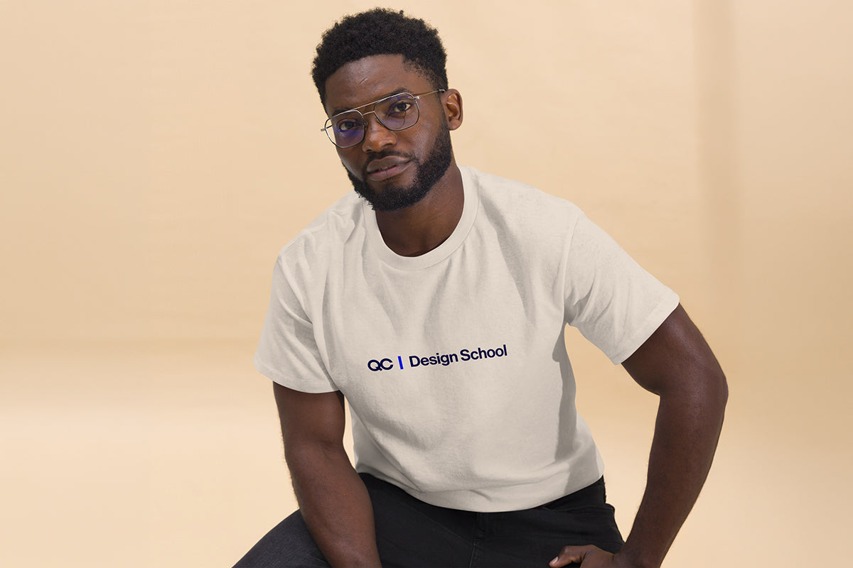 Man wearing a beige t-shirt with 'OC Design School' text on a beige background