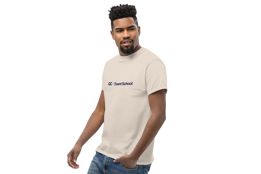 Man wearing a beige t-shirt with a QC Event School logo on a white background