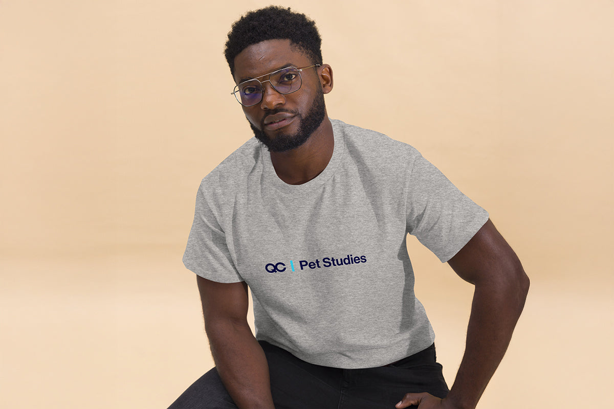 Man wearing a gray t-shirt with 'QC Pet Studies' logo on a beige background