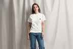Person wearing a white t-shirt with a Q logo on a plain background