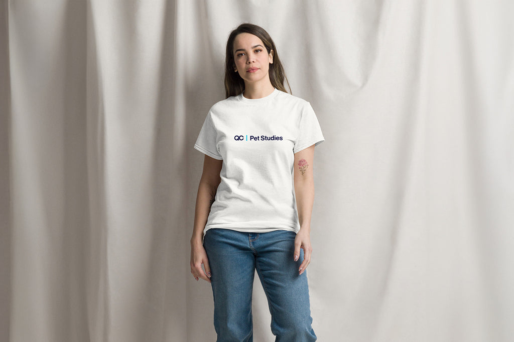 Person wearing a white t-shirt with QC Pet Studies on a plain background