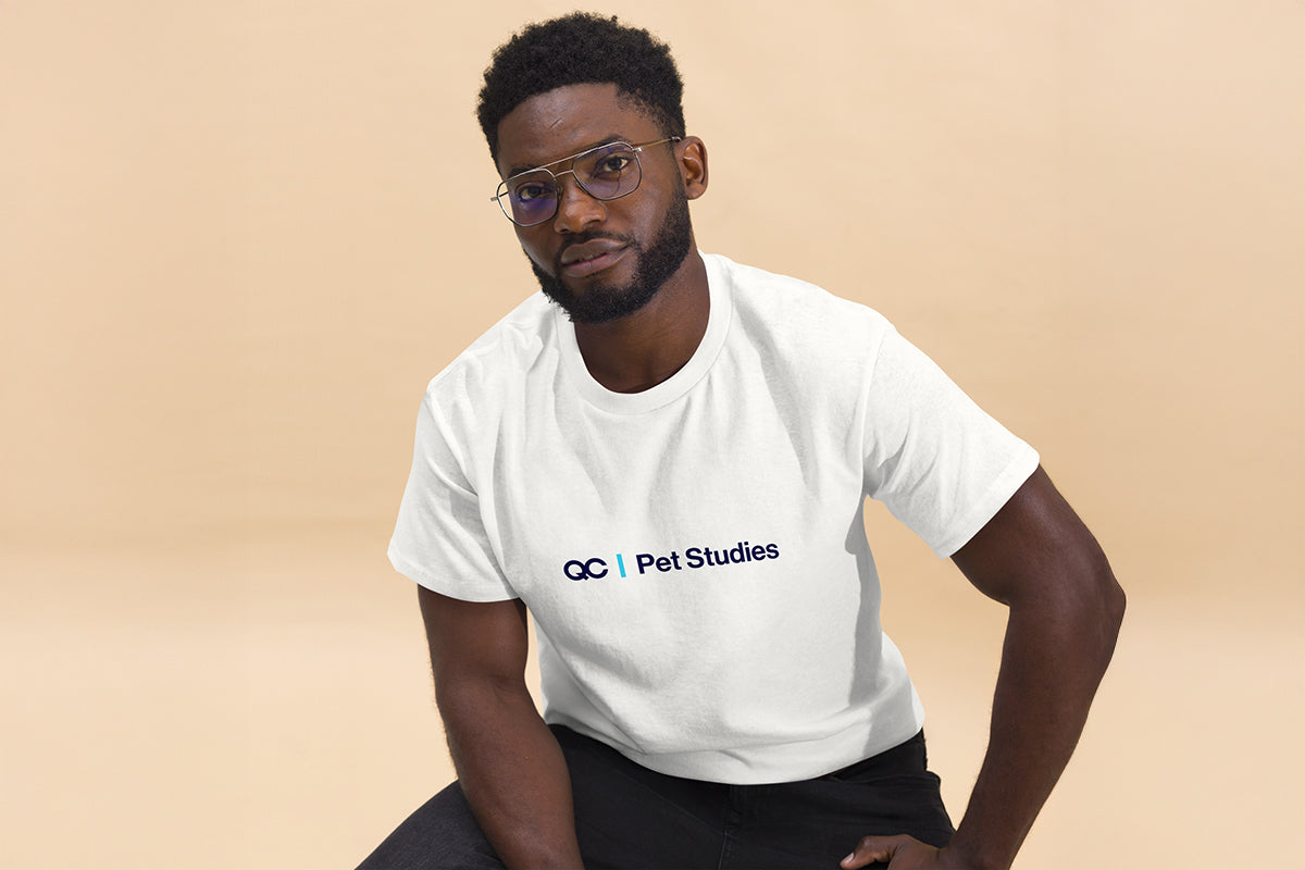 Man wearing a white t-shirt with 'QC Pet Studies' logo on a beige background
