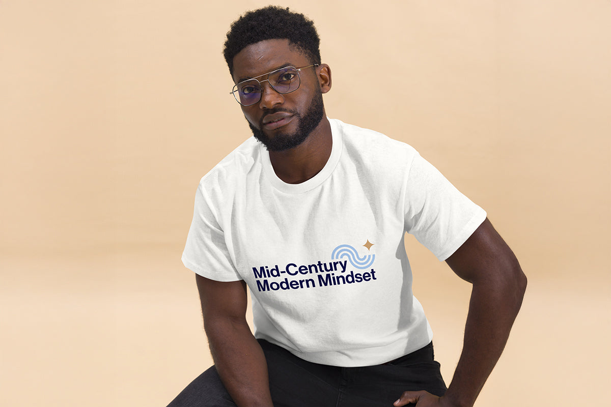 Person wearing a white t-shirt with 'Mid-Century Modern Mindset' text on a beige background