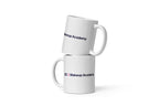 Two white mugs with 'QC Makeup Academy' text on a white background