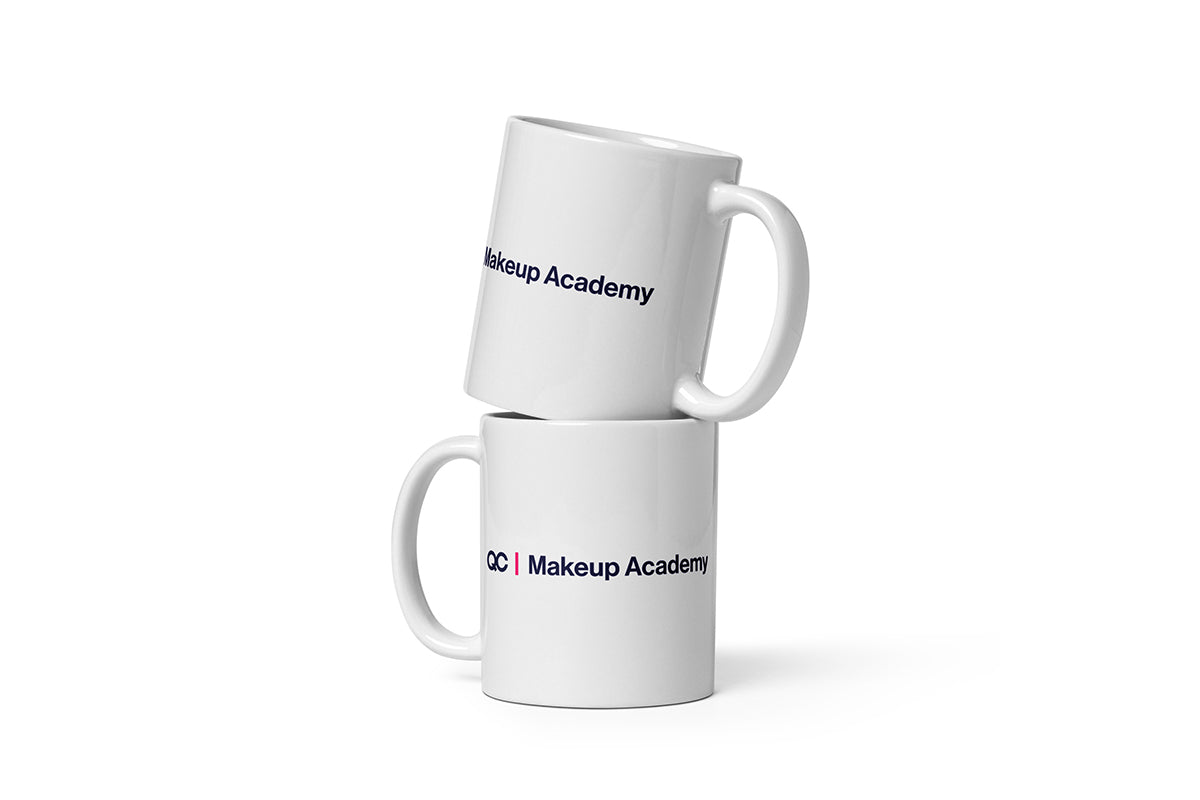 Two white mugs with 'QC Makeup Academy' text on a white background