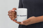 Person holding a white mug with 'QC Event School' logo against a light gray background