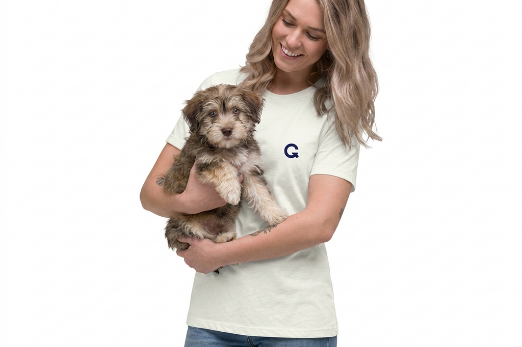 Woman holding a small dog wearing a white t-shirt with a logo on a white background