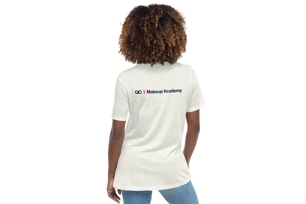 Person wearing an off-white t-shirt with 'QC Makeup Academy' text on the back against a white background